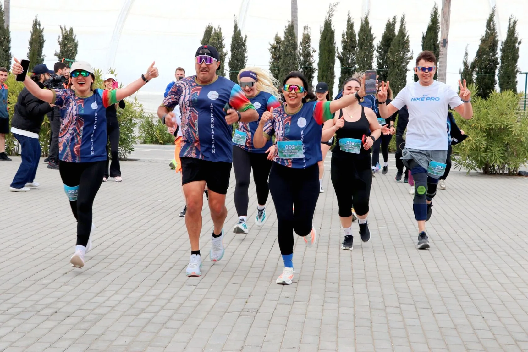 Бегуны Sea Breeze Run #2 на дорожке курорта, среди кипарисов